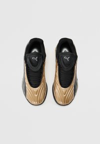Sorte og metallisk gull joggesko med et teksturert design, med en mesh-tunge, snøring og en logo på overdelen.