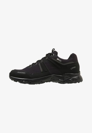 Scarpa da trekking bassa nera con chiusura a lacci, suola testurizzata e marchi visibili tra cui i loghi Mammut, Soft Shell e Gore-Tex.