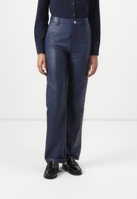 Pantalons en cuir bleu marine avec une coupe droite, dotés d'une fermeture à bouton et de poches avant discrètes, présentant une texture lisse et brillante.