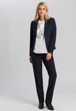 Navy suit set featuring a fitted blazer with two buttons and matching tailored trousers, paired with a white shirt with metallic design accents.
