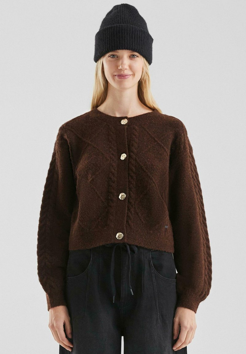 Bruine gebreide cardigan met een ronde halslijn, voorzien van een textuurpatroon, vijf gouden knopen aan de voorkant en ballonmouwen.