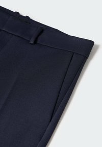 Granatowe spodnie o gładkiej fakturze, z płaskim przodem, szlufkami na pasek i wyraźnymi kantami, wykonane z lekkiego materiału.