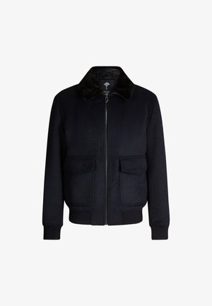 Veste bomber noire en mélange de laine avec une finition douce et texturée. Elle présente un col en fausse fourrure noire et deux poches avant avec une fermeture éclair.