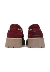 Bordowe zamszowe buty na grubej podeszwie, z złotymi elementami ozdobnymi i detalami przeszycia z tyłu. Teksturowana cholewka z platformą.
