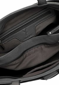 Interno di una borsa in pelle grigia con più scomparti, inclusa una tasca con zip e una fodera testurizzata, caratterizzata da dettagli di cucitura a contrasto.