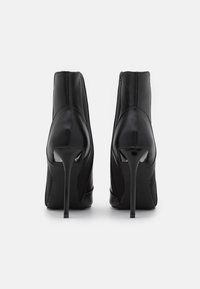 Czarne botki na wysokim obcasie, wykonane z gładkiej skóry, z ostrym noskiem i eleganckim designem, wyposażone w smukły obcas typu stiletto i minimalne akcenty.