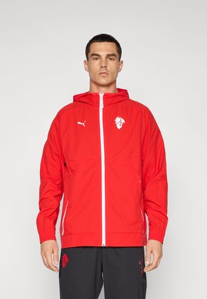 Rød vindjakke med lynlås foran, justerbar hætte, elastiske manchetter og hvide logoer. Materialet er let og glat.