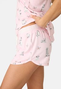 Sovkläder i bomull som består av en rosa topp och shorts. Tryckt med olika hundillustrationer och fjärilar. Elastisk midja med snörning.