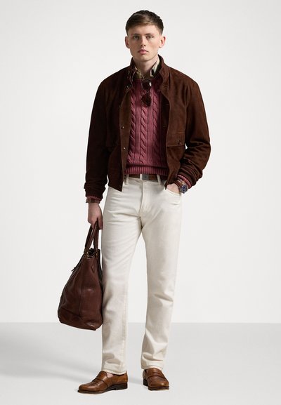 Brown suede jacket over a maroon cable-knit sweater, cream pants, brown loafers, and a brown leather bag. Plaid shirt collar visible.