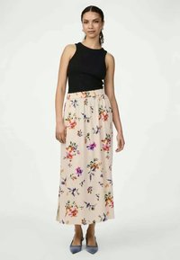 Musti kaelusega must topp, millele on sobitatud pikk, heledast beežist värvi lilleline seelik, millel on värvilised lilled ja elastne vöökoht. Sinised kontsad.