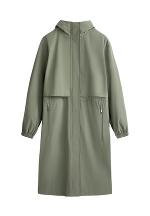 Long manteau à capuche en tissu vert discret avec des poignets élastiques et deux poches latérales à fermeture éclair. Texture lisse avec un design minimaliste.