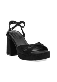 Sandalia de tacón alto de ante negro con un chunky block heel, diseño de punta abierta, correas entrelazadas y correa en el tobillo con cierre de hebilla.
