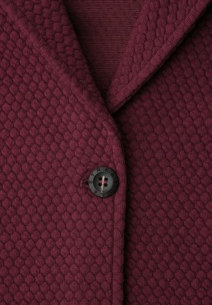 Bordeauxroter Strickcardigan mit strukturierter Oberfläche, ausgestattet mit einem schwarzen Knopf mit vier Löchern und der seitlichen Prägung "STREET".