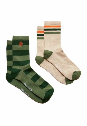 Zwei Paare Crew-Socken; ein Paar grün mit dunkelgrünen Streifen und orangefarbenem Logo, das andere beige mit grünen Zehen und orangefarbenen, schwarzen und grünen Streifen.
