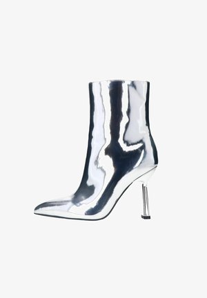 Bottines argentées à finition métallique brillante, bout pointu et talon aiguille mince et réfléchissant. Texture lisse, design élégant.