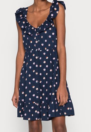 Florales Sommerkleid mit marineblauem Hintergrund, Rüschen-Trägern und ausgestelltem Saum. Verziert mit mehrfarbigen Blumenmustern und Knopfdetails.