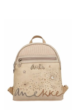 Petit sac à dos beige avec poche zippée, étoiles décoratives, broderie sur le thème de la science et le nom de la marque "Anekke" en écriture stylisée sur le devant.
