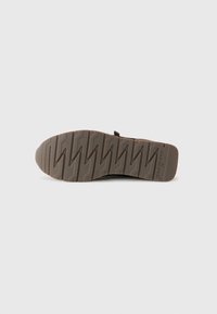 Semelle de chaussure marron avec un motif de semelle en zigzag. La semelle extérieure présente le nom de la marque "Paul Green" embouti près de la zone du talon.