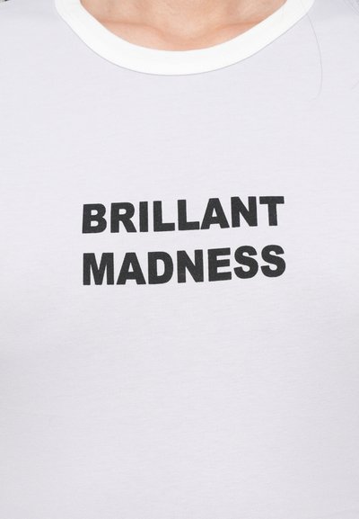 Tricou alb cu decolteu rotund, pe care este inscripționat textul "BRILLANT MADNESS" cu un font negru bold, centrat pe piept.