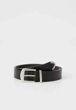 Ceinture en cuir noir roulé avec une boucle en métal argenté et une petite attache en métal gravée "OBEY" sur fond blanc.