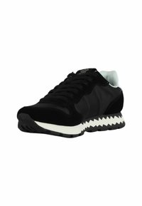Sneaker atletico nero con un mix di sopra in suede e tessuto, suola bianca a zigzag, design con lacci e colletto imbottito.