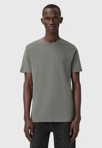 Harmaa lyhythihainen t-paita, joka on valmistettu pehmeästä kankaasta. Paidoissa on pyöreä pääntie ja hillitty brodeerattu logo rinnassa.