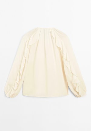 Blouse de couleur crème avec de longues manches volumineuses, ornées d'accents froncés le long des épaules et d'un col froncé. Texture de tissu lisse.