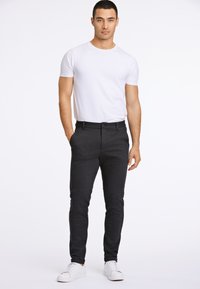 Slim-fit, donkergrijze broek van een zachte, gestructureerde stof met een knoopsluiting, zijzakken, gecombineerd met een effen wit T-shirt en witte sneakers.