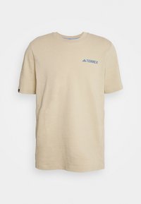 Beige bomulds-T-shirt med korte ærmer, rund hals og blåt "TERREX"-logo på brystet. Simpelt design, blød tekstur og afslappet pasform.