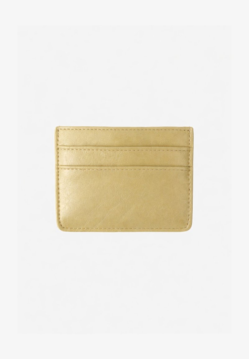 Porte-cartes en cuir beige avec trois fentes horizontales pour cartes et coutures apparentes sur fond blanc.