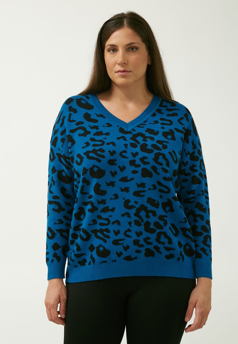 Blå v-hals sweater med et sort leopardmønstret. Fremstillet af blødt stof med ribbekanter ved ærmer og bund, som giver en afslappet pasform.