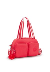 Rosa nylonväska med dubbla framfickor, vita och röda randiga handtag och en fluffig apcharm fäst vid dragkedjan.