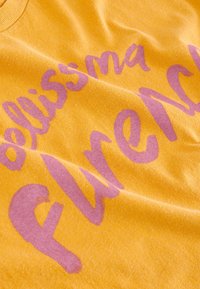 T-shirt gialla in cotone con una grande scritta grafica rosa che recita "bellissima fire", con una superficie morbida e testurizzata e una scollatura rotonda.