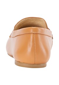 Barna bőr lapos, slip-on cipő, látható varrással és sima talppal, hátulról, fehér háttér előtt bemutatva.