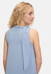 Lichtblauw mouwloos blouse met een gladde textuur, voorzien van een gestrikt accent aan de achterhals en een ontspannen pasvorm over de schouders.