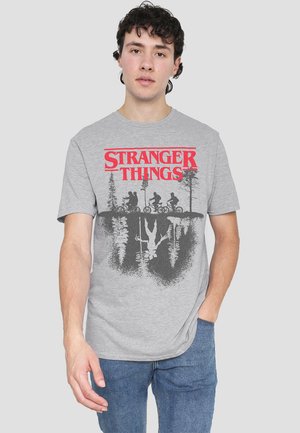Graues Kurzarm-T-Shirt mit rotem "Stranger Things"-Text, grafischem Design von Figuren auf Fahrrädern und Silhouetten von Bäumen.
