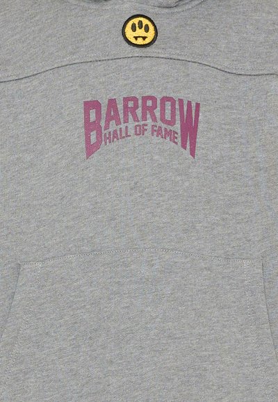Felpa grigia con cappuccio con la scritta "BARROW HALL OF FAME" in viola e una piccola toppa a forma di faccina sorridente di vampiro gialla vicino all'orlo del collo.