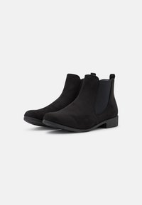 Botas de tobillo de ante negro con paneles laterales elásticos, una lengüeta y un tacón bajo de bloque. Textura suave y diseño de punta redondeada.