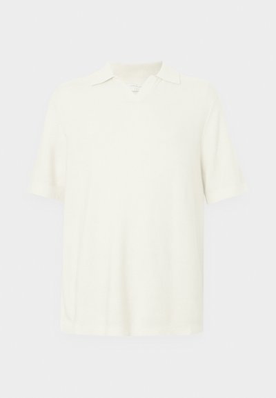 Polo majica s kratkimi rokavi, svetlo kremne barve, izdelana iz teksturiranega materiala, z v-izrezom in klasičnim ovratnikom.