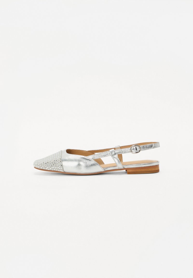 Sudraba slingback apavi ar punktētu purngalu, iezīmēti ar teksturētu priekšpusi un uzliktiem studiem, kā arī platu koka papēdi. Metāliska apdare un regulējama siksna.