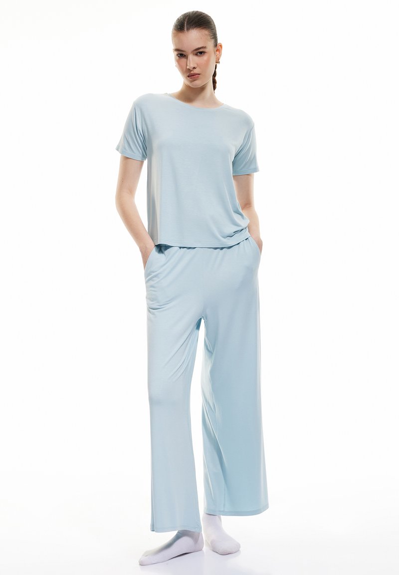 Lichtblauw loungewear set, met een kort mouwtop met een losse pasvorm en wijde broek, gemaakt van zachte, ademende stof.