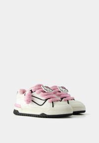 Bílé tenisky s černými detaily, vyznačující se růžovými plyšovými tkaničkami a nášivkami Hello Kitty po každé straně. Texturovaná gumová podrážka.