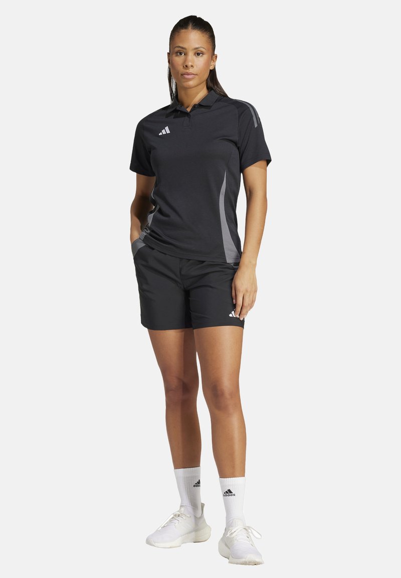 Zwarte polo met grijze accenten, gecombineerd met zwarte shorts. Bevat het Adidas-logo en is gemaakt van een lichtgewicht, gestructureerde stof.