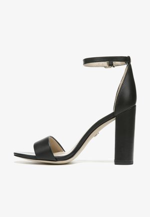 Zwarte high-heeled sandaal met een brede band over de tenen, een enkelbandje en een chunky, vierkante hak. Gemaakt van glad leer en met een minimalistisch ontwerp.
