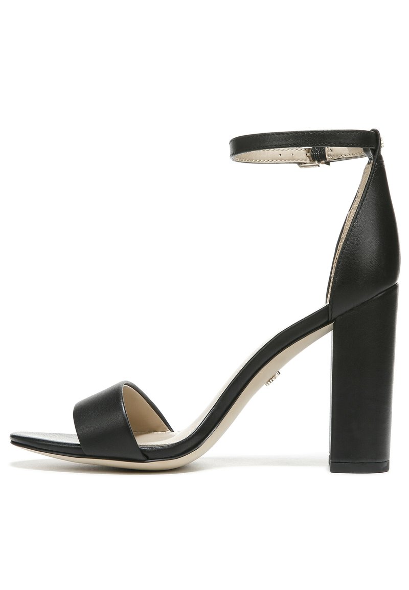 Zwarte high-heeled sandaal met een brede band over de tenen, een enkelbandje en een chunky, vierkante hak. Gemaakt van glad leer en met een minimalistisch ontwerp.