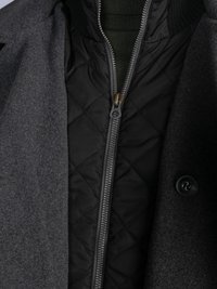 Gray wool coat layered over a black quilted jacket. The jacket features a zip closure and ribbed collar. Both have button and zipper details.
