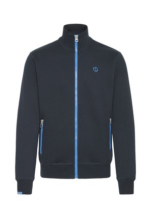 Tamno plava zip-up jakna od mekog materijala, s visokim ovratnikom, plavim patentnim zatvaračem i dva bočna džepa s patentnim zatvaračima. Plavi logo na prsima.