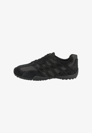 Zapato deportivo negro que combina materiales de ante y malla, con costuras en contraste, punta redondeada y suela de goma texturizada.