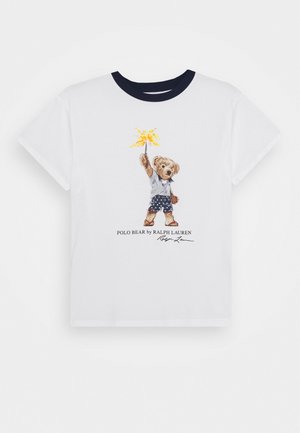 Weißes T-Shirt mit marineblauem Kragen, das einen Bären in Shorts zeigt, der eine brennende Wunderkerze hält, und darunter den Text "POLO BEAR by RALPH LAUREN".
