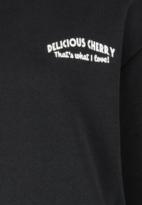 Black cotton sweatshirt featuring curved white text: "DELICIOUS CHERRY" above "That's what I love!" printed on the front.